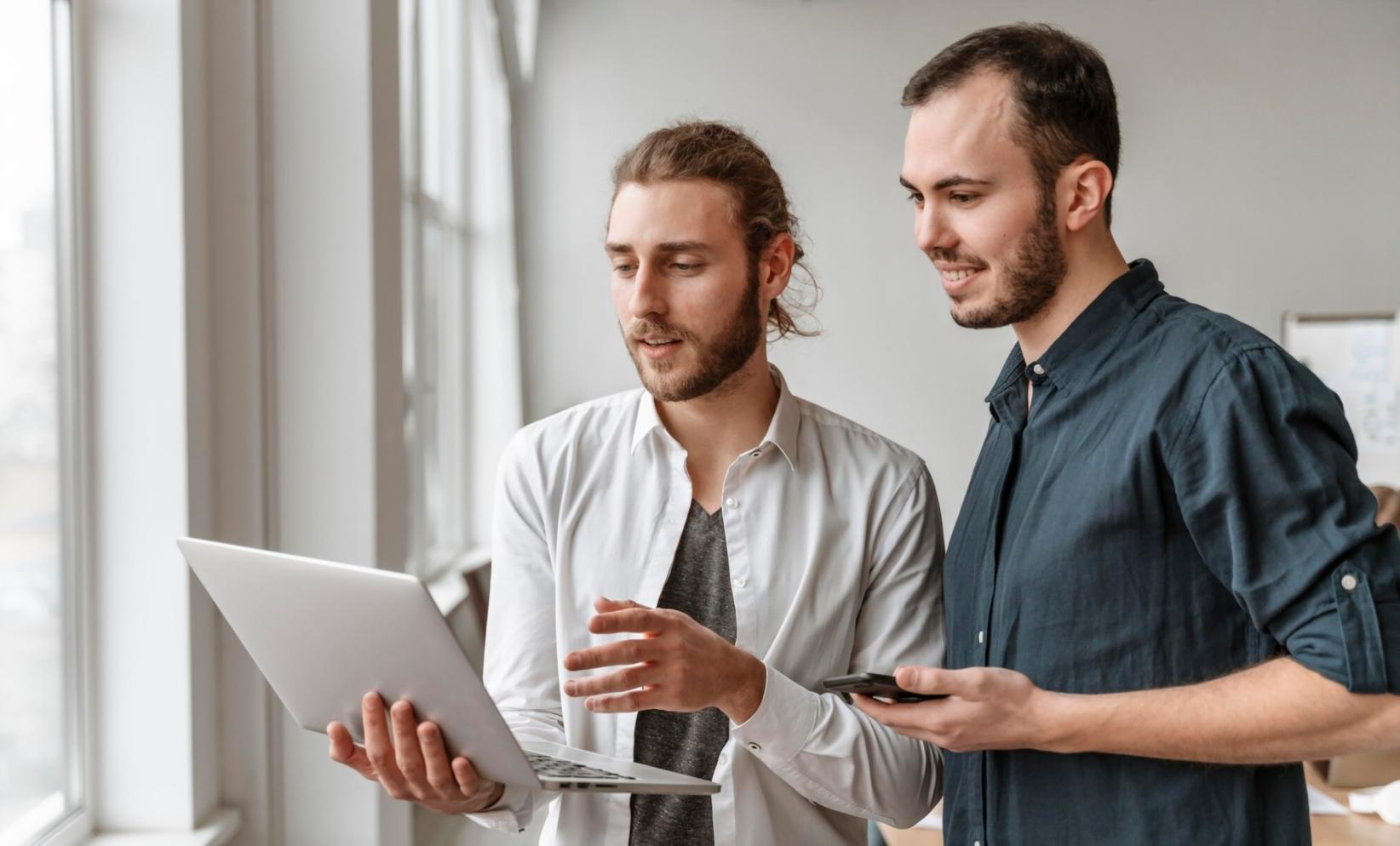 Students working on investment analysis with charts and financial data displayed on computer screens